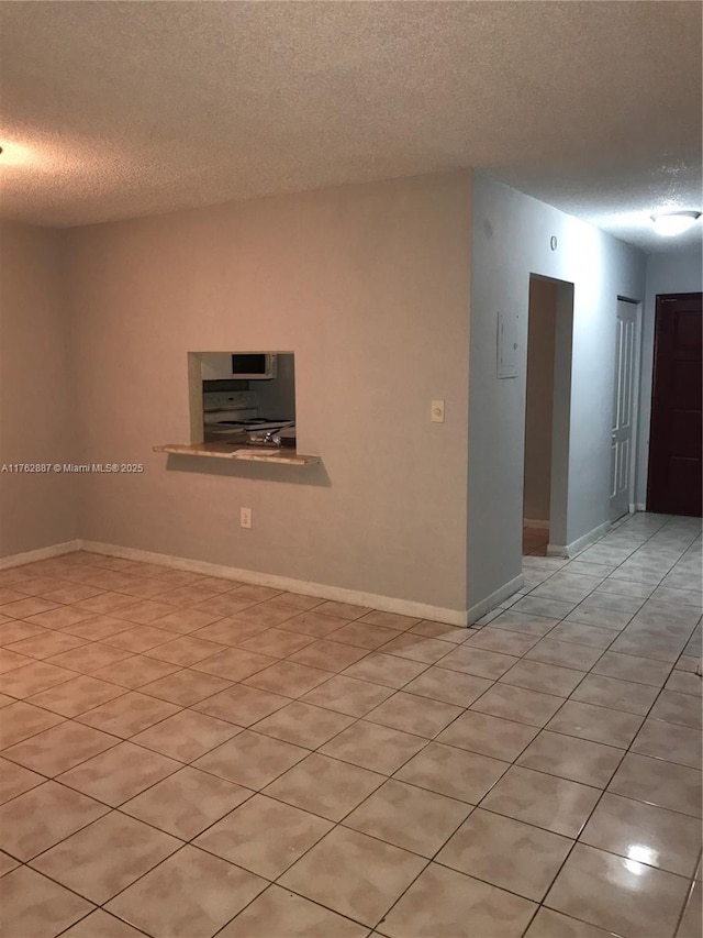 spare room featuring baseboards and a textured ceiling