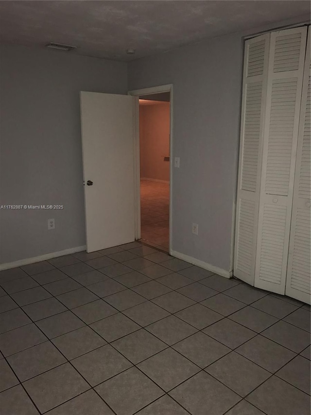 unfurnished bedroom featuring baseboards, visible vents, and a closet