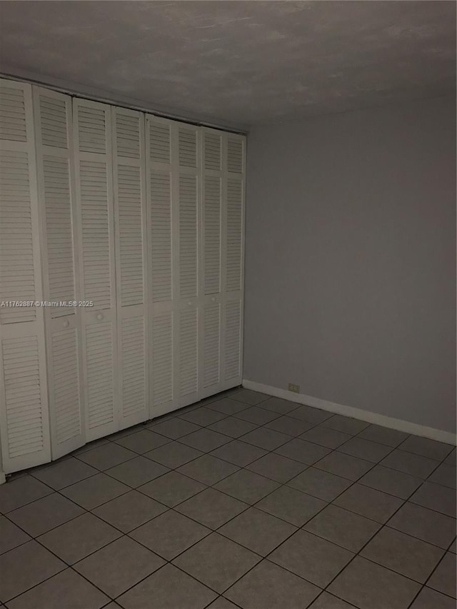 unfurnished bedroom with baseboards and a closet