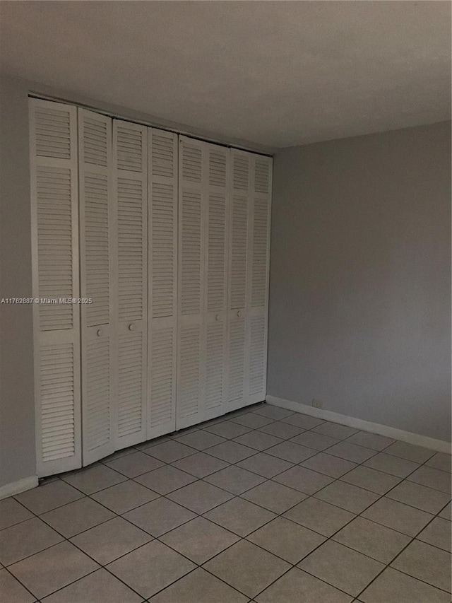 unfurnished bedroom with baseboards and a closet