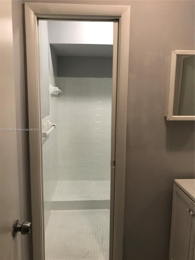 full bath with vanity and tiled shower