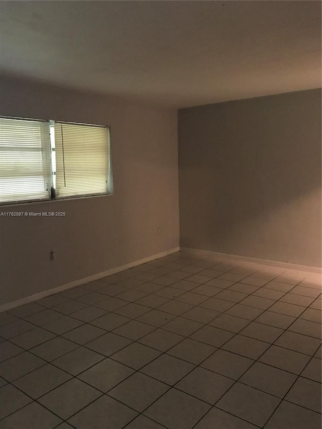 unfurnished room with baseboards