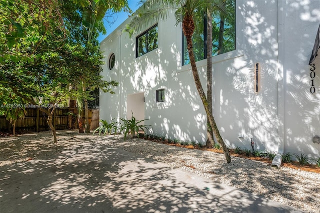 view of property exterior featuring stucco siding and fence