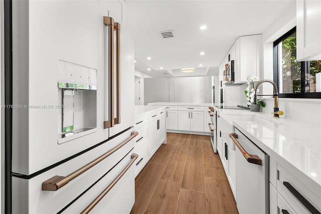 kitchen with visible vents, recessed lighting, white appliances, white cabinets, and light wood finished floors