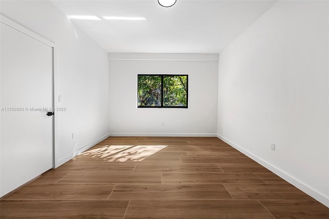 unfurnished room featuring wood finished floors and baseboards