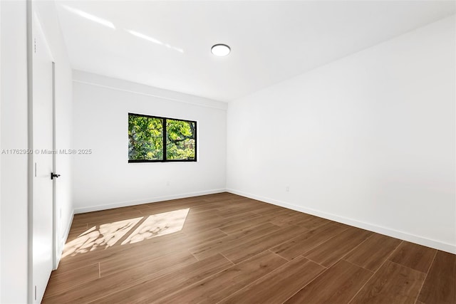 unfurnished room featuring baseboards and wood finished floors