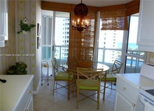 dining space with a notable chandelier and wallpapered walls