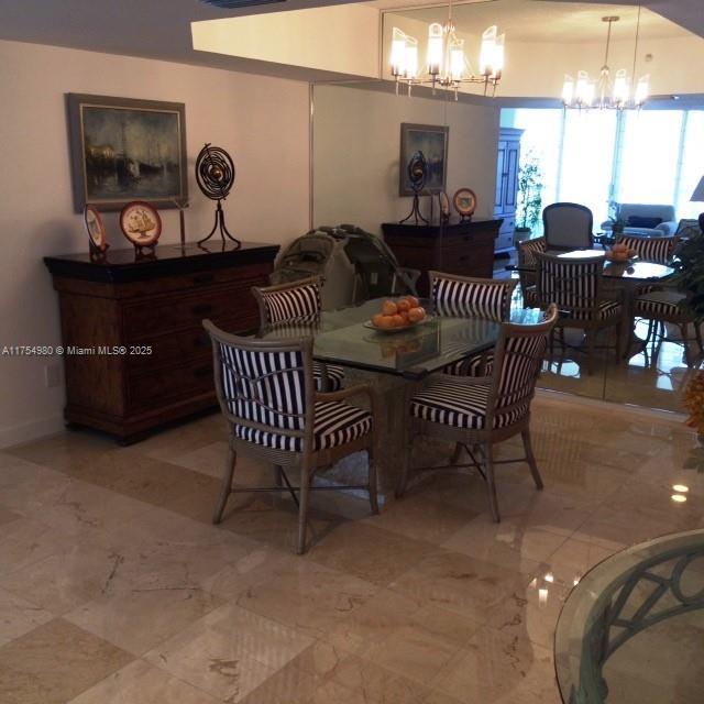 dining room with an inviting chandelier and marble finish floor