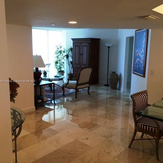 living area featuring visible vents and expansive windows