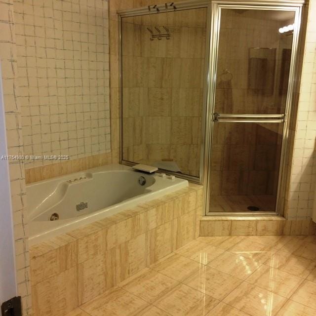 full bath featuring tile patterned flooring, a shower stall, and a whirlpool tub