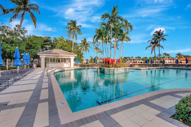 community pool featuring an outbuilding, a patio area, and an exterior structure