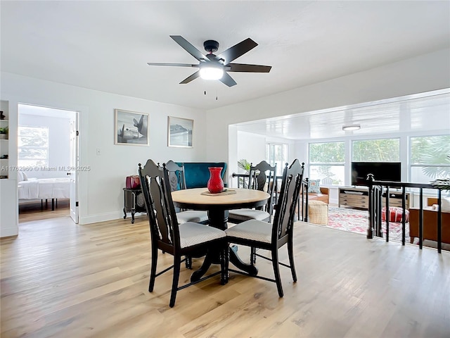 dining space with baseboards, light wood-style flooring, and a ceiling fan