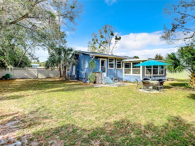 rear view of property featuring a patio, a lawn, a fenced backyard, and entry steps