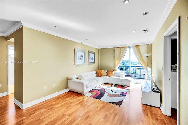 living area with visible vents, crown molding, and wood finished floors