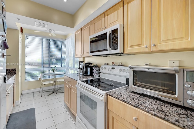 kitchen with light tile patterned floors, ceiling fan, light brown cabinetry, and white range with electric stovetop