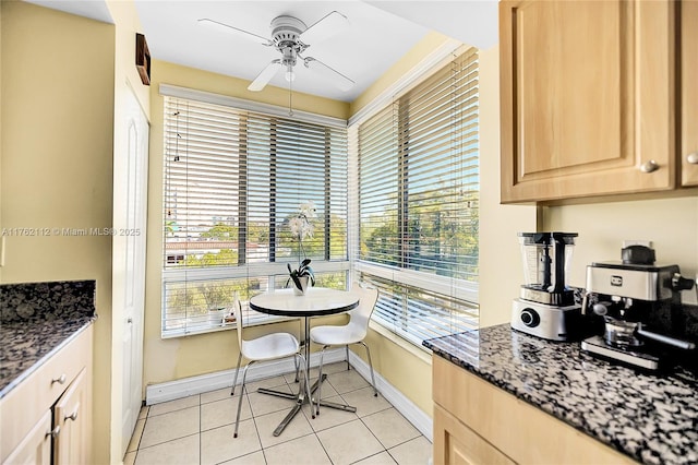 dining room with light tile patterned floors, baseboards, and ceiling fan