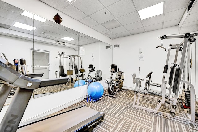 workout area featuring a paneled ceiling, visible vents, and carpet floors