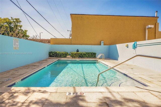 pool with a patio and fence