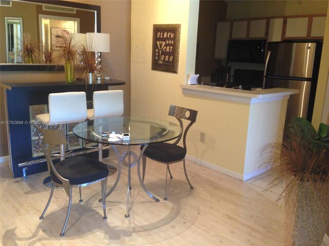 dining room featuring light wood-type flooring and baseboards