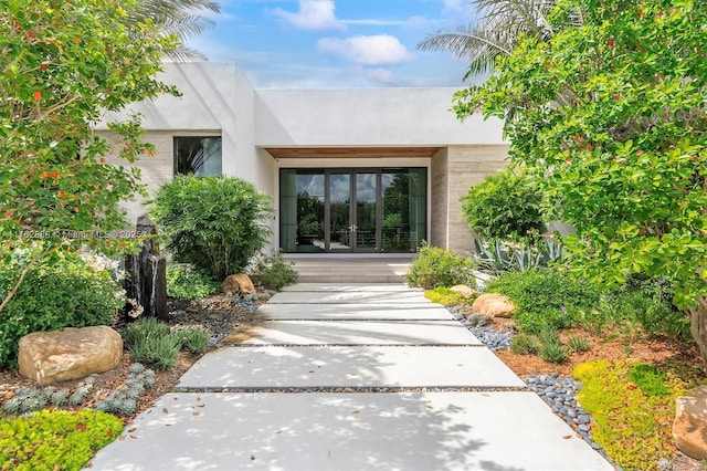 view of exterior entry featuring brick siding and french doors