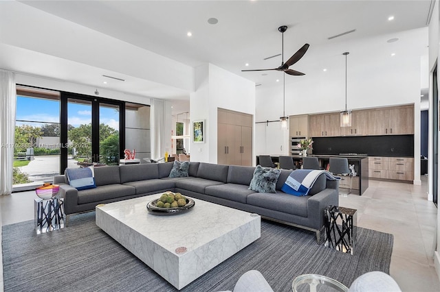 living room with recessed lighting, visible vents, a towering ceiling, and light tile patterned flooring