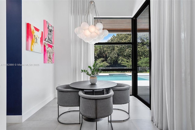 dining space featuring a wall of windows, baseboards, a wealth of natural light, and a chandelier