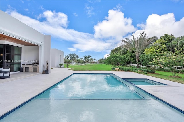 view of swimming pool with a patio, exterior kitchen, and a pool with connected hot tub