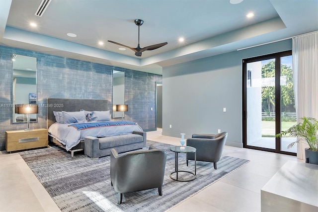 tiled bedroom featuring visible vents, a tray ceiling, recessed lighting, access to exterior, and an accent wall