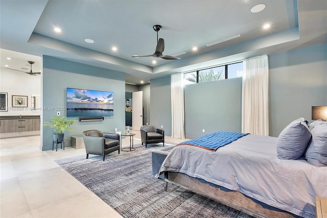 bedroom with recessed lighting, connected bathroom, a raised ceiling, and tile patterned flooring