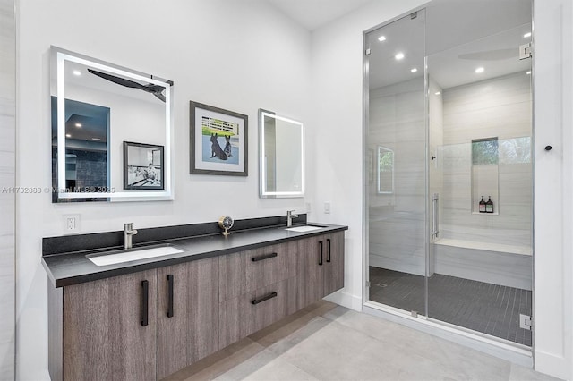 full bath with a sink, double vanity, recessed lighting, and a shower stall