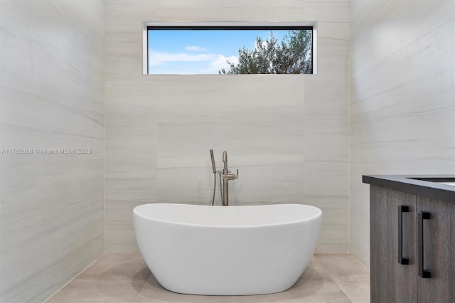 bathroom with a freestanding tub and tile walls