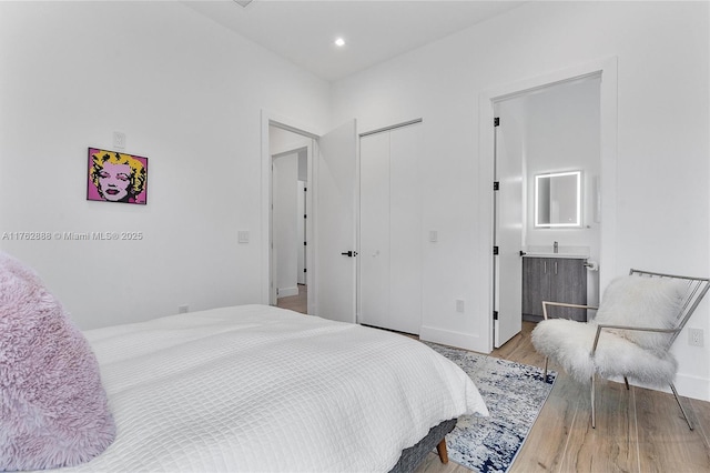 bedroom featuring recessed lighting, a closet, and wood finished floors