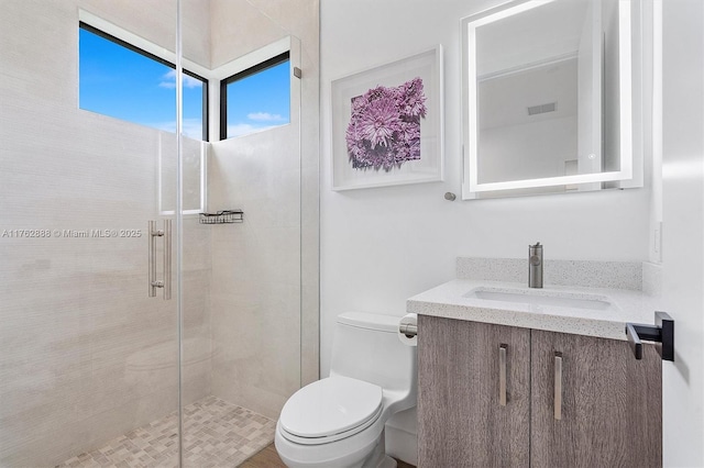 bathroom featuring visible vents, vanity, toilet, and a shower stall