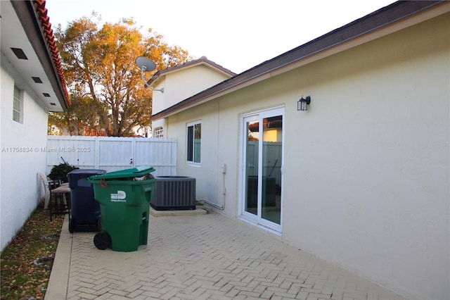 view of patio featuring central air condition unit and fence