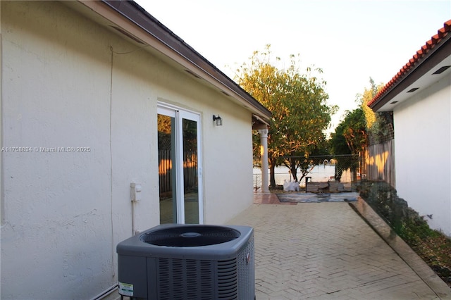 view of patio / terrace with central air condition unit and fence