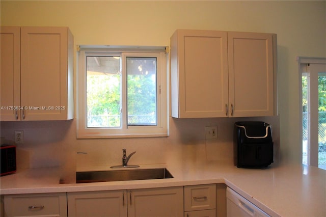 kitchen with a sink, a healthy amount of sunlight, and light countertops