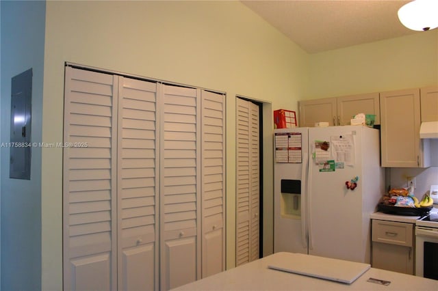 kitchen featuring under cabinet range hood, white appliances, and light countertops