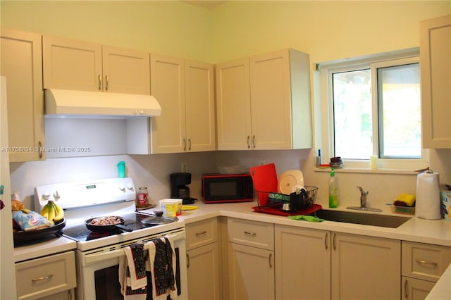 kitchen with under cabinet range hood, white electric stove, light countertops, and a sink