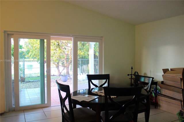 dining space with vaulted ceiling and light tile patterned floors