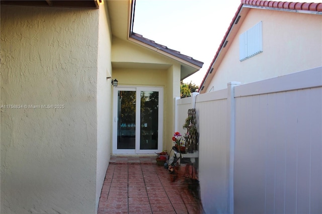 entrance to property with stucco siding and fence