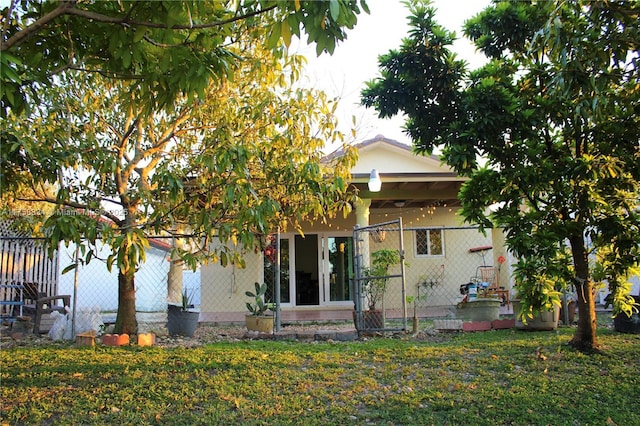 rear view of property with fence and a lawn