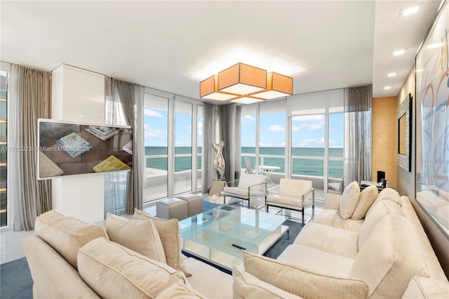 living room featuring floor to ceiling windows, recessed lighting, and a water view