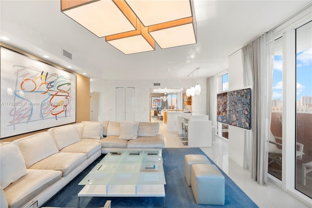 living area featuring visible vents and a notable chandelier