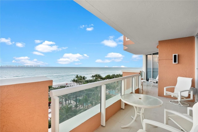 balcony featuring a view of the beach and a water view