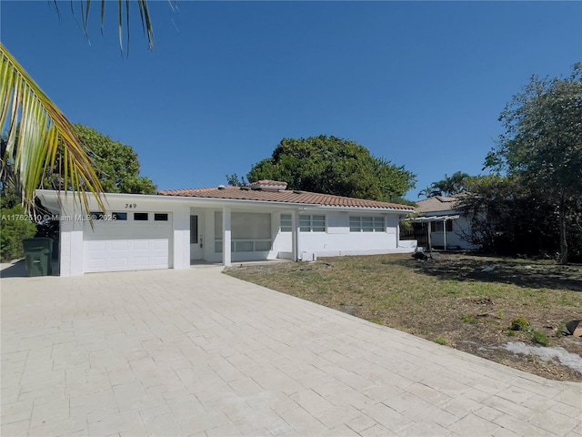 single story home with a garage, driveway, stucco siding, and a tiled roof