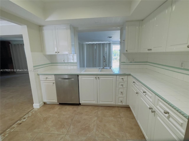 kitchen with dishwasher, white cabinets, tasteful backsplash, and a sink