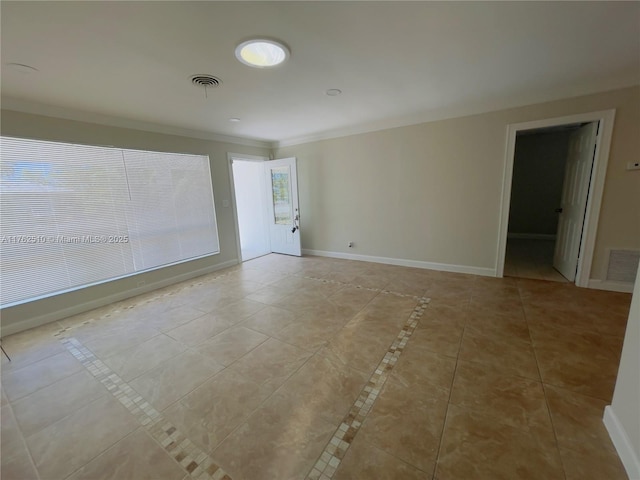 unfurnished room with light tile patterned floors, visible vents, baseboards, and ornamental molding