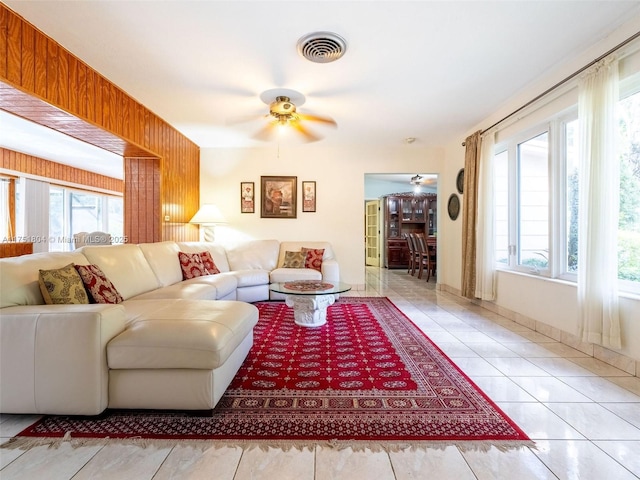 living room featuring tile patterned floors, visible vents, and ceiling fan