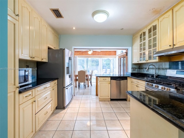 kitchen with visible vents, under cabinet range hood, a sink, appliances with stainless steel finishes, and light tile patterned floors