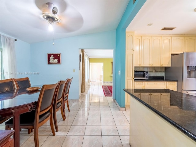 dining area featuring lofted ceiling, light tile patterned floors, a ceiling fan, and visible vents